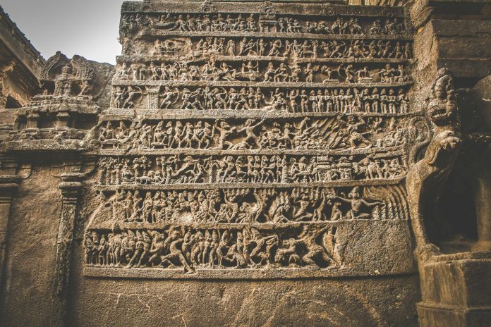 Carved pictures on stone wall of ancient temple