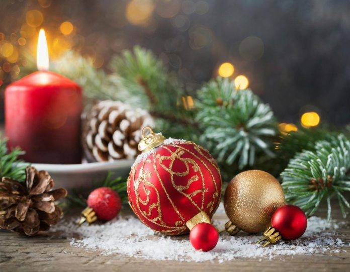 Christmas background with red balls, decorations and fir, selective focus on candle