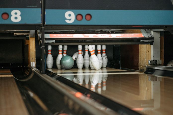 White and Red Bowling Pins with Green Bowling Ball