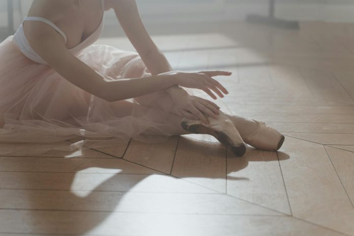 Pastel Image of a Ballerina Sitting on a Wooden Floor